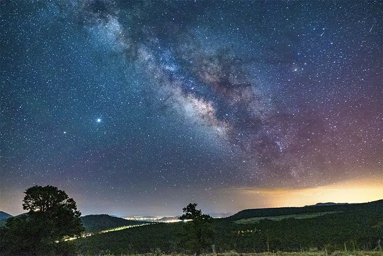 The Milky Way over a horizon of mountains